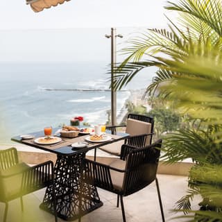 Modern ironwork table on a balcony overlooking the ocean around Lima