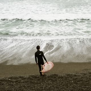 Surfers in wet suits enjoy the dramatic Pacific waves of Lima’s Costa Verdes beach