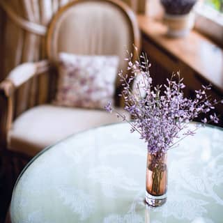 Close-up of a small vase of lavender on a circular glass table