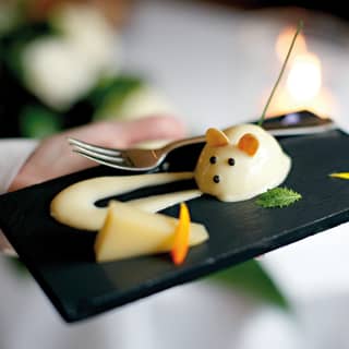 Close-up of a cheese-mousse in the shape of a mouse on a black slate