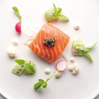 Birds-eye-view of a smoked salmon dish garnished with caviar and radishes