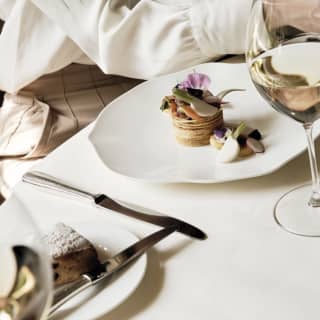 A stack of baby carrot, radish and fresh vegetables, topped with petals, elevates the kitchen garden in a fine dining dish.