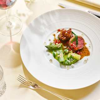 Looking down on Summer Lunch dish of pink Herwick lamb served with fresh asparagus and thick wild garlic sauce.