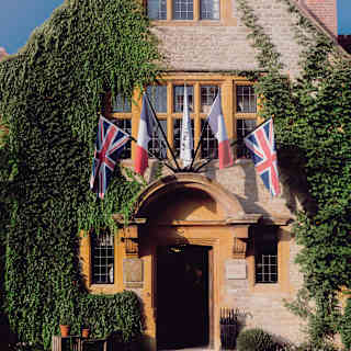 Two Union Jack and French Tricolour flags flank Le Manoir's own above the arch stone pediment of the restaurant's entrance.