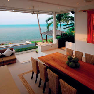 Beachfront villa open-air dining area overlooking turquoise waters