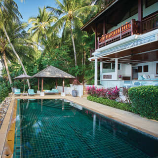 Beachfront villa and emerald-tiled outdoor pool overlooking calm seas