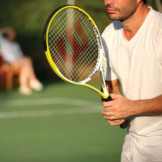 Guests enjoy tennis in the sunshine at the hotel court