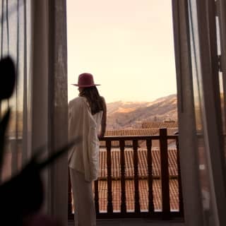 A woman standing on the balcony of the Palacio Suite
