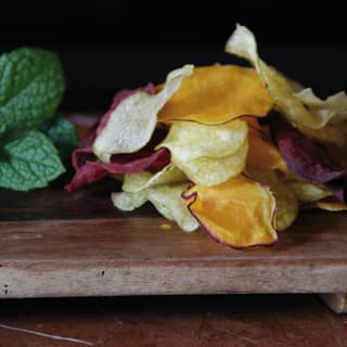 Close-up of multi-coloured vegetable chips and mint leaves