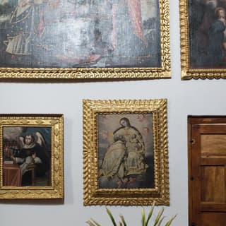 Period Peruvian artworks in elaborate gilded frames are displayed on the hotel walls