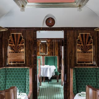 Aisle of a Pullman carriage with marquetry and armchairs designed by Wes Anderson