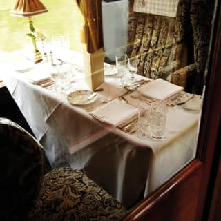 View through a partition window of a formal dining table on a vintage train