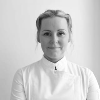 A black and white image of award-winning celebrity chef, Anna Haugh, dressed in traditional high collar chef whites