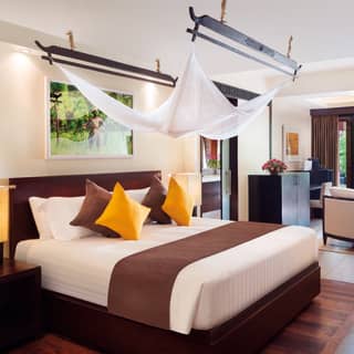 Spacious hotel suite with modern Asian-style decor in yellow and brown hues