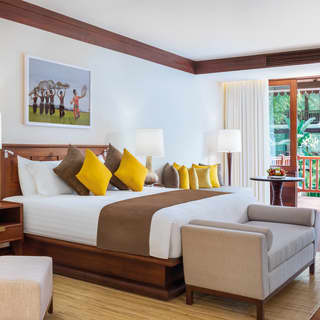 Spacious hotel suite with yellow and tan accents and polished wooden floor