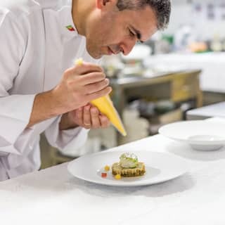 Executive Chef Luís Pestana concentrates on putting the final touches to an elegant fish dish, using a purée piping bag.