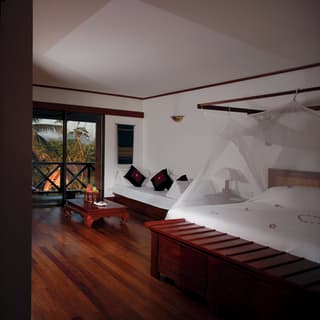 Split-view of a luxurious hotel room with a pillowy bed and grand balcony