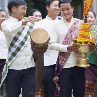 Traditionelle laotische Musikgruppe, die auf Trommeln spielt und Hochzeitsdekorationen trägt