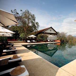 Outdoor infinity pool and U-shaped poolside with rows of sunbeds