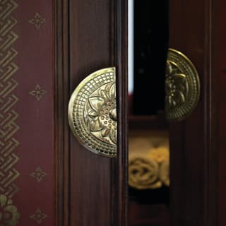 Close-up of teakwood doors with gleaming gold semi-circle handles