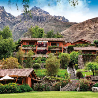 Collection of villa style buildings spilling down a hillside in Sacred Valley
