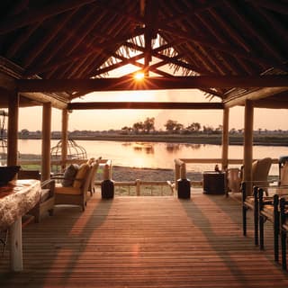 Sunset at the Fish Eagle Bar at Eagle Island Lodge overlooking the river from an open wooden terrace