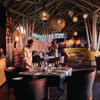 Open-air luxury restaurant hut with chocolate-coloured accents and rattan chandeliers