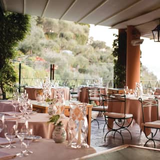 Terracotta columns carry the terrace restaurant roof providing delicious shade among stunning views of the tree-lined cliffs