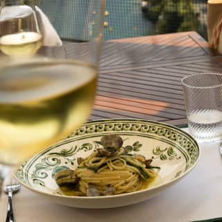 A lunch of linguine, clams and samphire with a glass of white wine. Through the balcony railings unrivalled views of Portofino