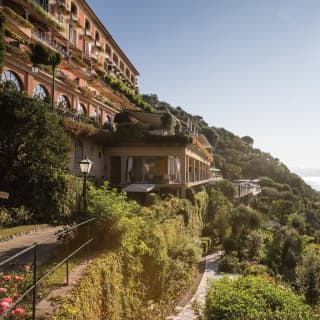 Classical Italian villa perched on a hilltop surrounded by lush Mediterranean gardens