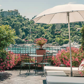 A parasol and sun loungers on the balcony of Splendido Mare balcony over looking the Portofino harbour 