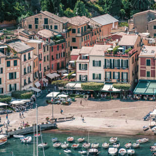 Sailing boats in the harbour of Portofino with town houses lining the shore