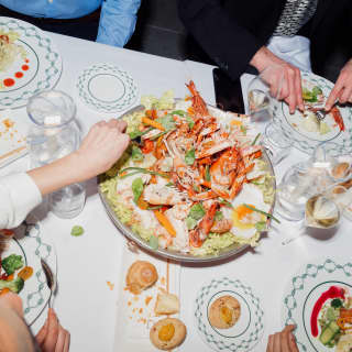 group of friends sharing a big seafood plate at Dav Mare restaurant