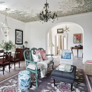 The chic living area, with upholstered eighteenth century Neapolitan chairs, Venetian settee, tiled floors and tapestry rug.