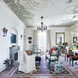 The white walls of the living area, with its dark antique pieces and rich red tiles, creates space and a cool fresh feel.