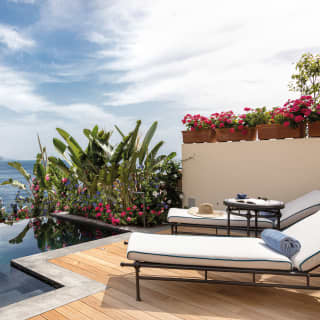An infinity pool appears to fall away from the private deck to the deep of Mazarro Bay. Tall lush plants provide seclusion