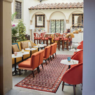 Bar area in a double-height atrium with burnt orange, yellow and blue furnishings