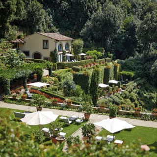 Gorgeous tiered hilltop gardens with sunbeds and parasols on manicured lawns