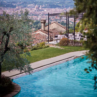 Aerial view of an outdoor pool on a hilltop overlooking the city of Florence