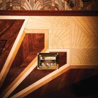 Close-up of ornate art-deco marquetry on a gleaming wood-panelled wall