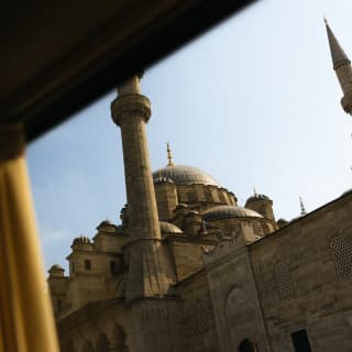 Looking up at the minarets, dome and beautiful Ottoman architecture of Istanbul's New Mosque, seen through the train window.