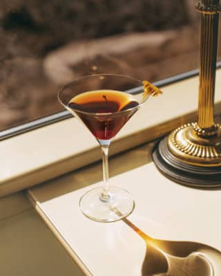 A cocktail on a table by the window in the dining car