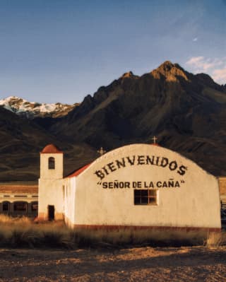 duas alpacas sentadas em frente às montanhas de arco-íris de Vinicunca