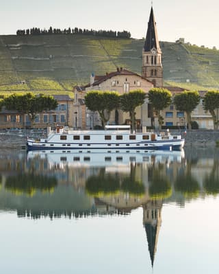 The Napolean cruises the calm River Rhône, which reflects Tain-L'Hermitage and its famous Côtes du Rhône vineyards beyond.