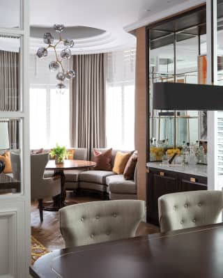 Hotel suite dining area with a polished wood table and contemporary grey chairs