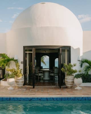 View across the pool and into the villa, with stunning white dome roof, and through the living room's windows on to the sea.