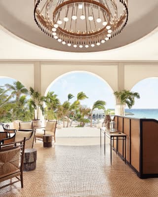 Hotel guest lobby area with archways and modern circular chandelier