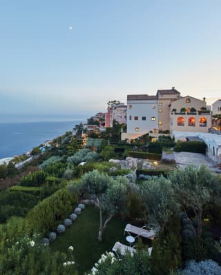 Lush Italian gardens surrounding a luxurious hilltop villa at sunset