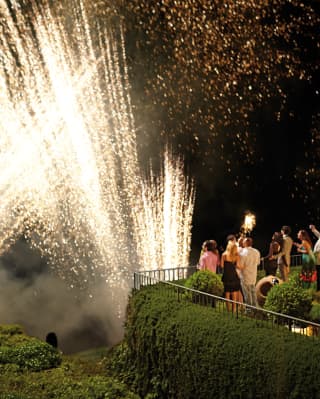 Guests gather on a garden terrace to watch the spectacular Torello firework celebrations in honour of Our Lady of Sorrows.