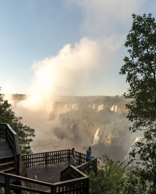 A couple photographing the Iguassu Falls at sunrise